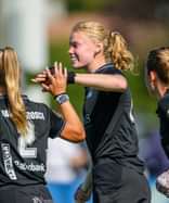 Lilly Stoffelsma feliciteert Amy van den Bosch na een HGC-doelpunt.